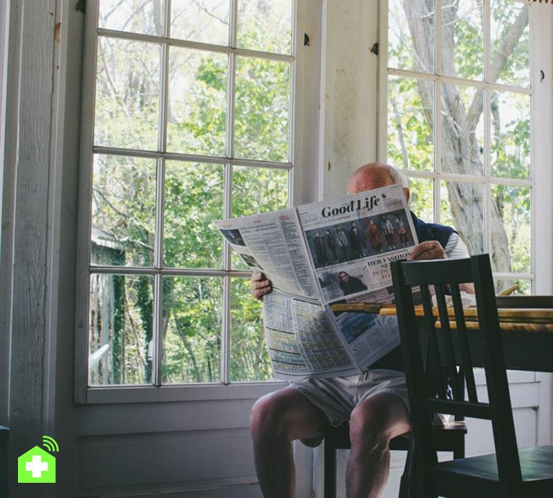 man reading newspaper while sitting on chair